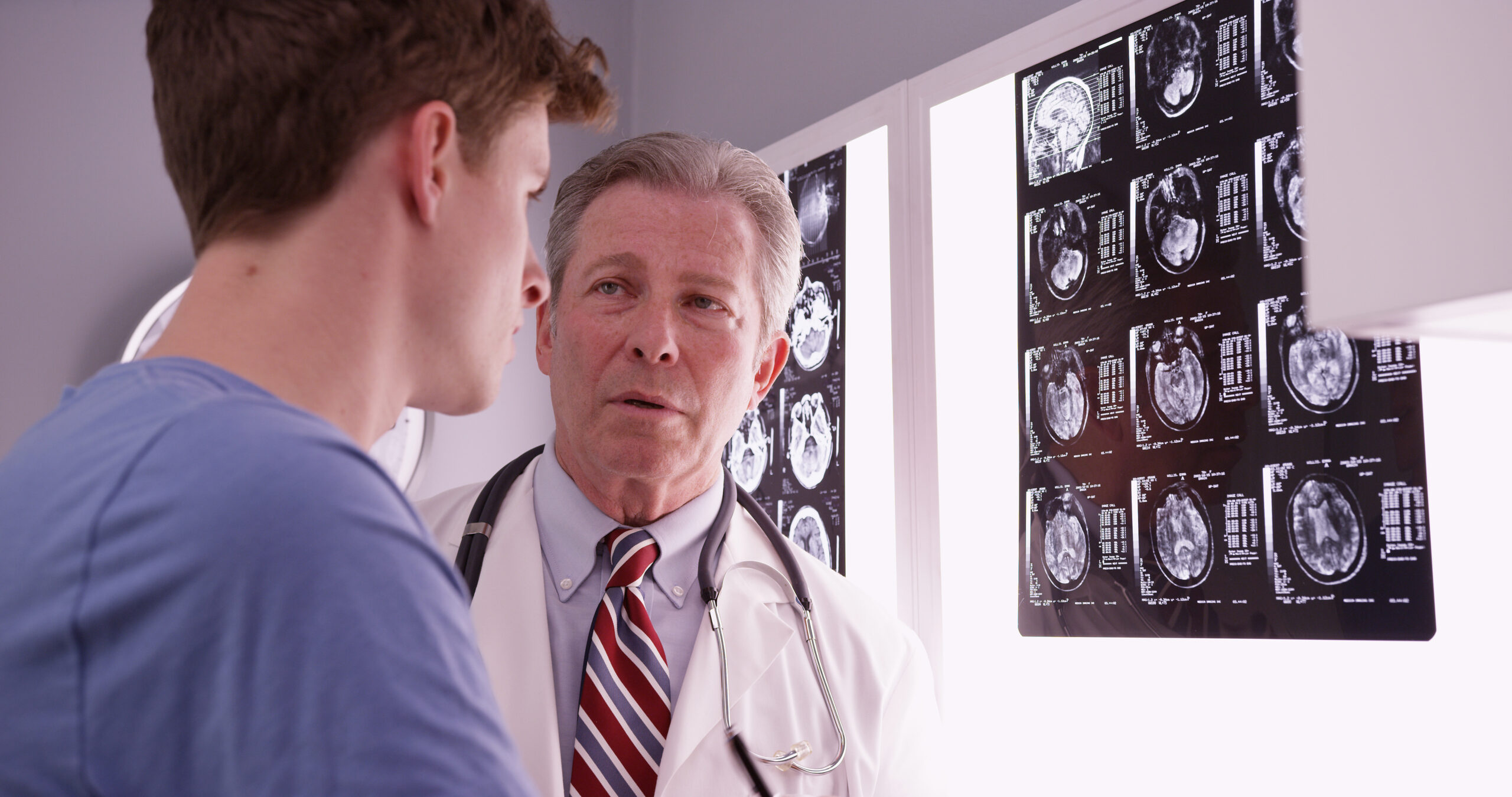 Young man reviewing brain x-rays with his physician